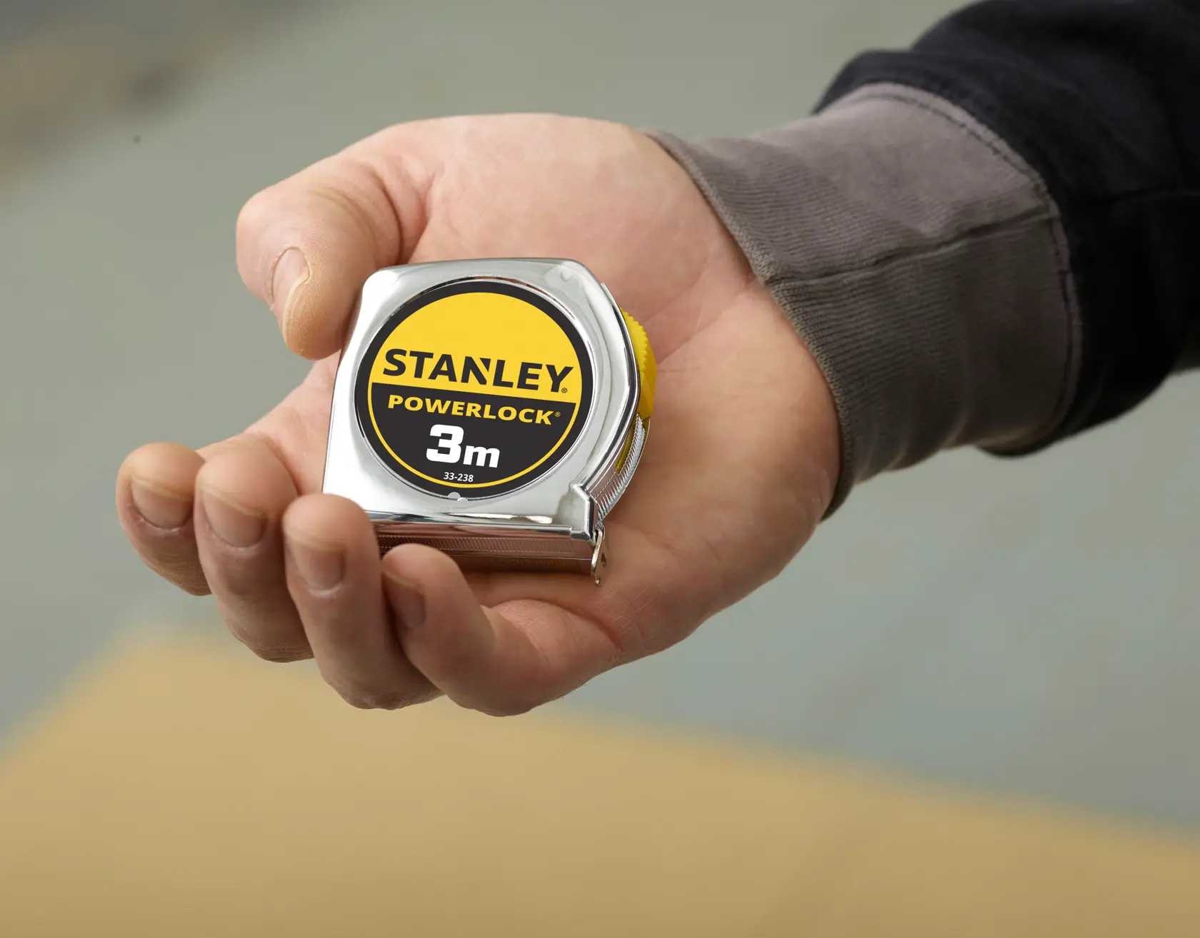Foto des STANLEY 0-33-238 PowerLock Maßbands in der Hand, gelb und schwarz, 3m, Kategorie Fotografie.