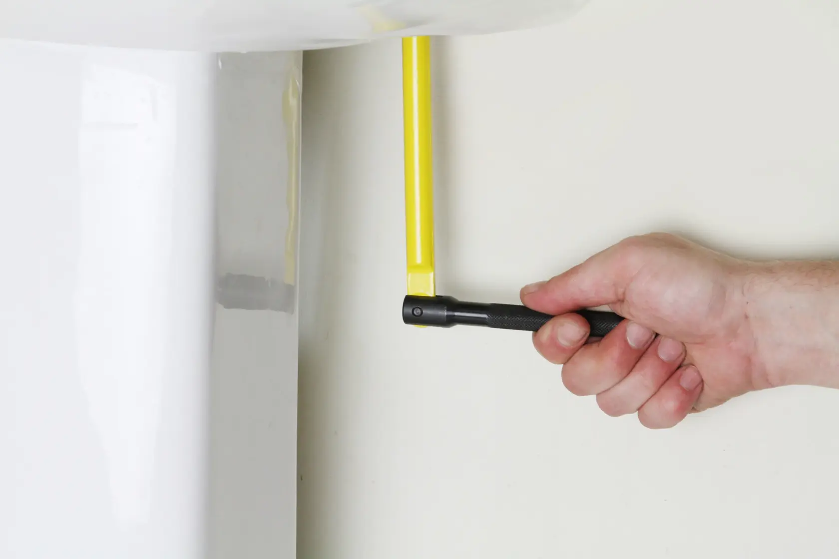 STANLEY 0-70-453 angle adaptor being used to tighten a yellow bolt near a white fixture, close-up.