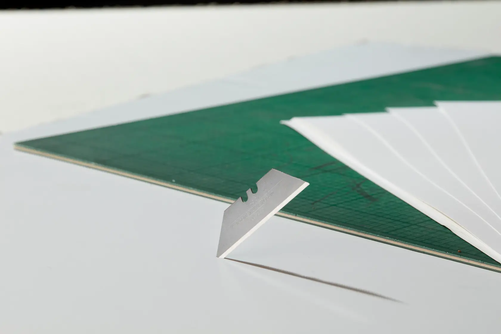 STANLEY 1-11-921 Universalmesser schneidet schwarzes Material, Nahaufnahme von gelbem Griff und Klinge im Einsatz.