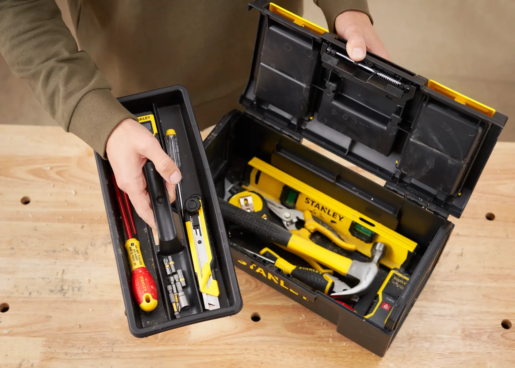 STANLEY 1-79-216 boîte à outils en plastique ouverte avec outils sur table en bois, vue de dessus.