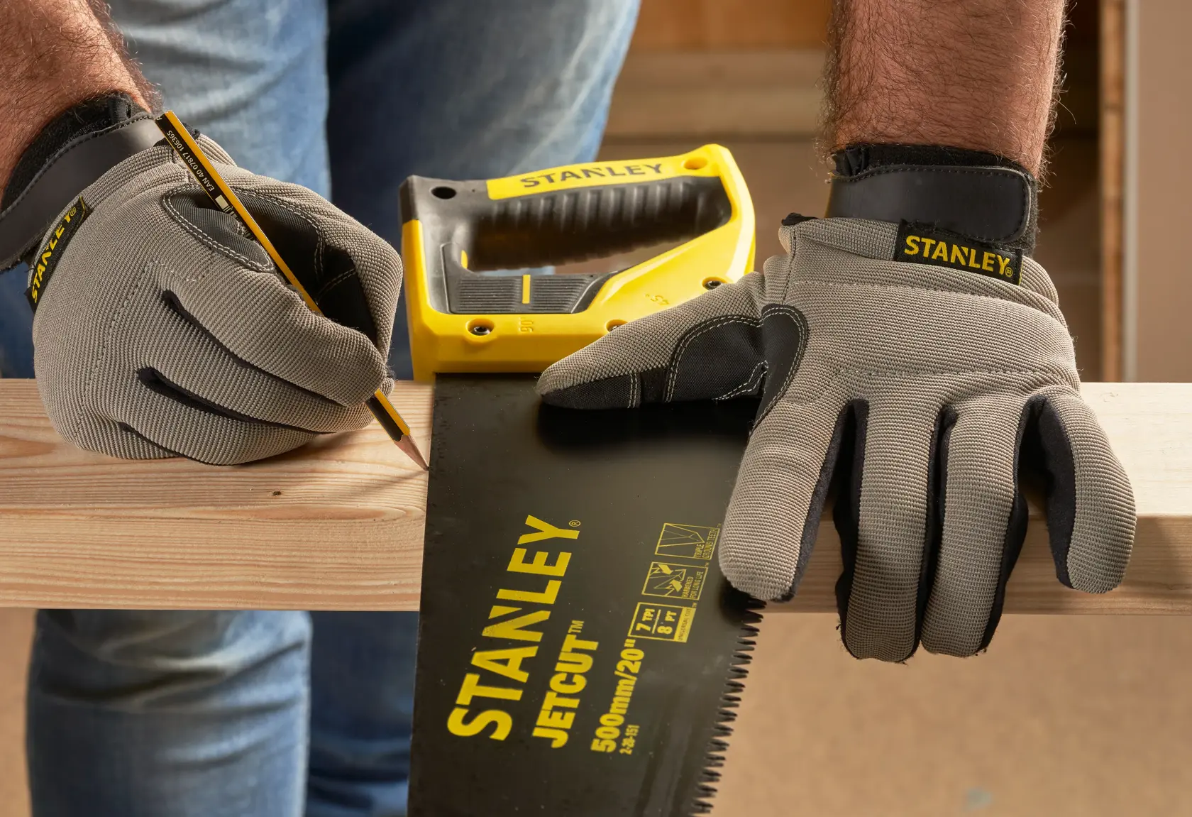 STANLEY 2-20-151 scie à main et gants marquant du bois, photographie en gros plan.