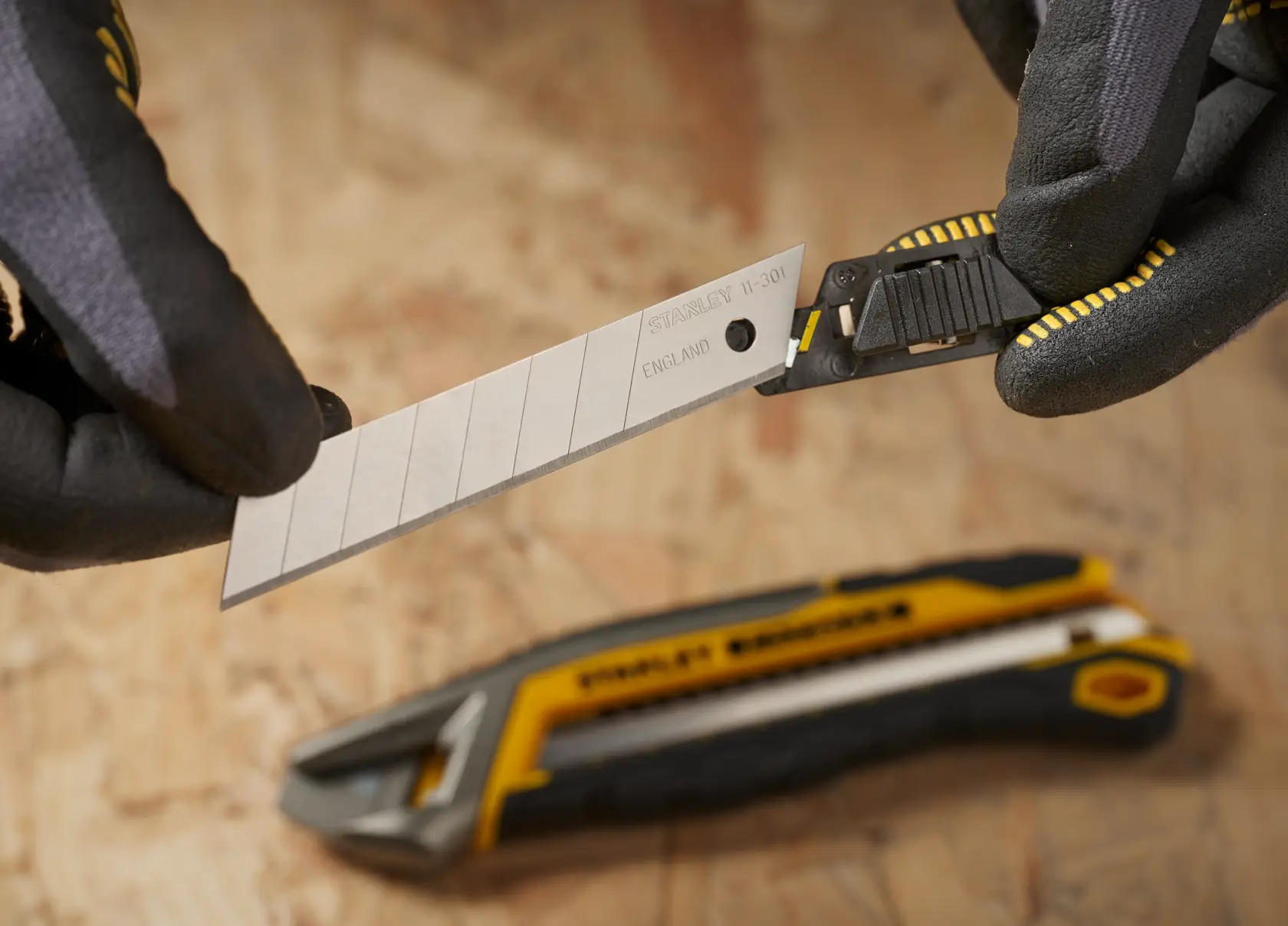 Photo of STANLEY 3-11-301 snap-off utility knife blade being replaced, with gloves holding the blade.