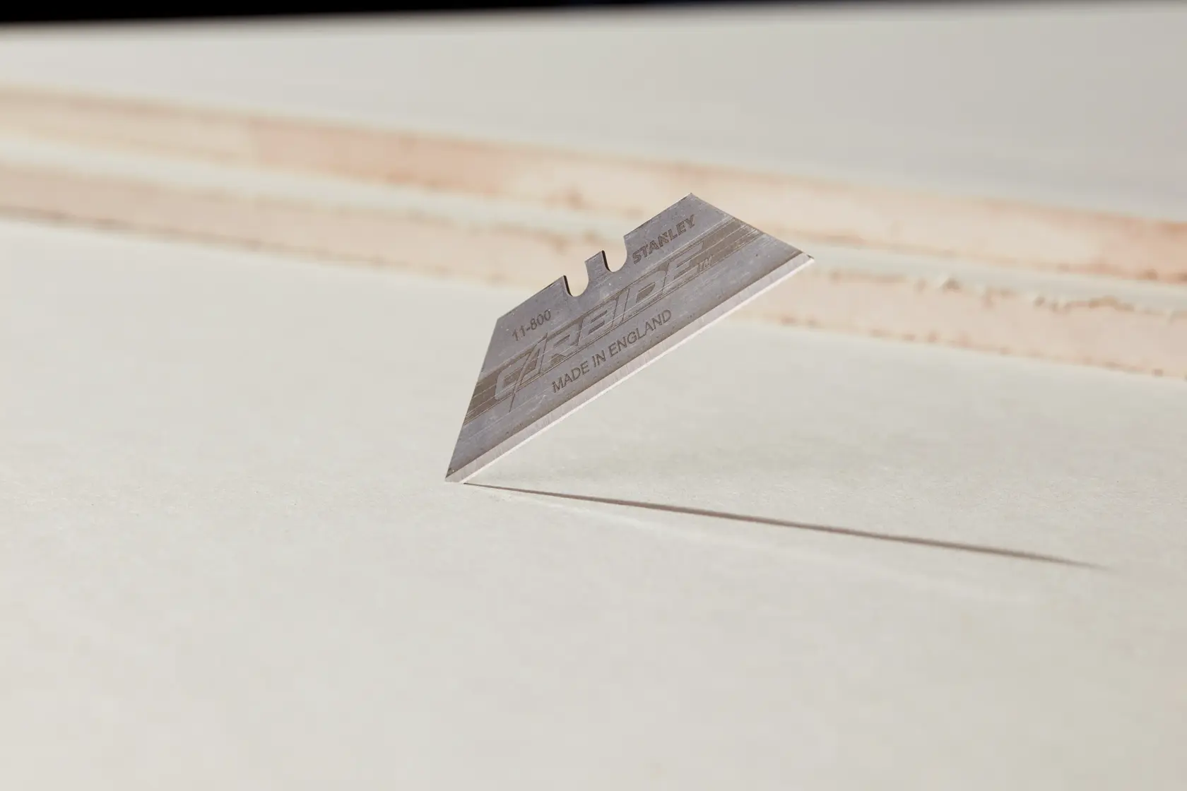 Photo of STANLEY 8-11-800 utility blade on white background, sharp edge visible, product photography angle.