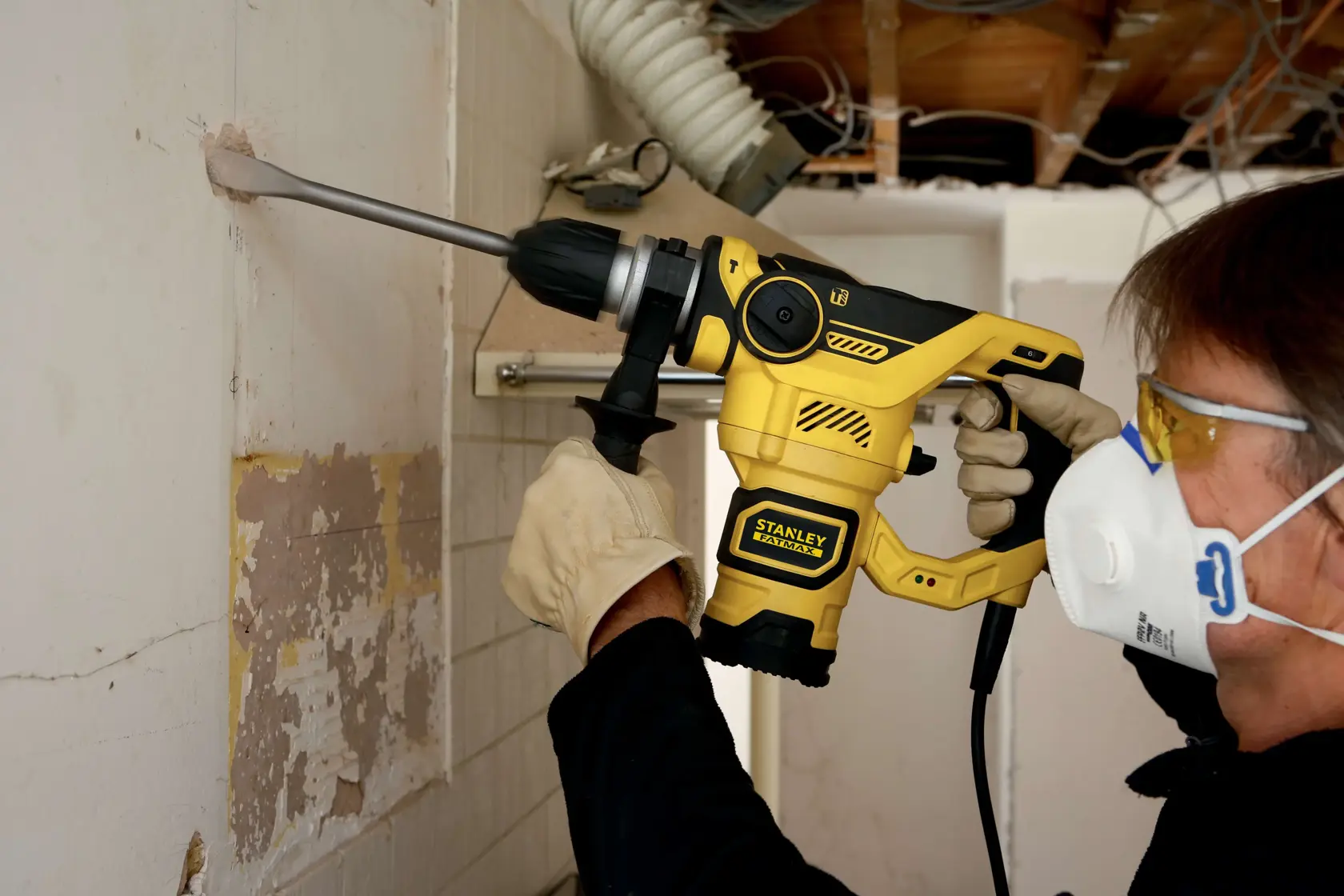 Martello rotativo STANLEY FME1250K in uso, design giallo e nero, perfora cemento in cantiere.