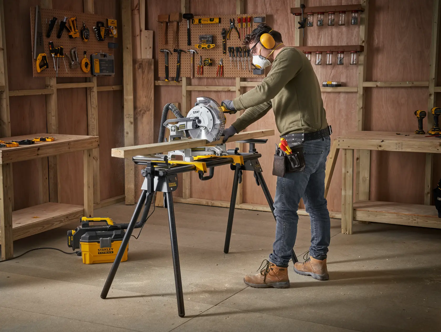 STANLEY FME790-XJ scie à onglet en utilisation sur établi, homme coupant du bois en atelier.