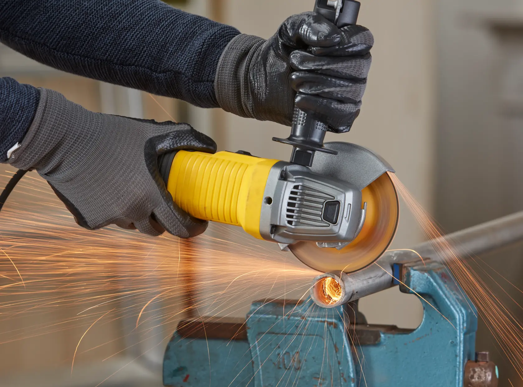 STANLEY FMEG210K smerigliatrice angolare in uso, taglio di tubo metallico con scintille, fotografia ravvicinata.