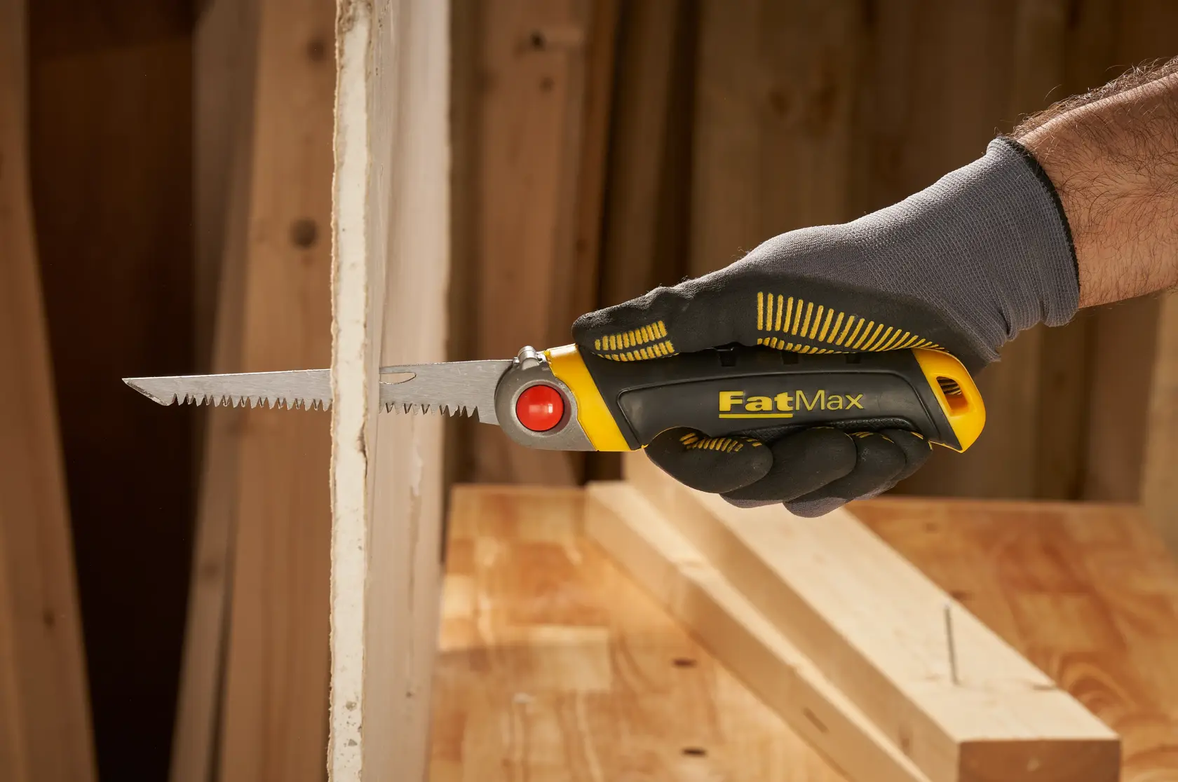 STANLEY FMHT0-20559 FatMax folding saw cutting drywall, close-up view in gloved hand.