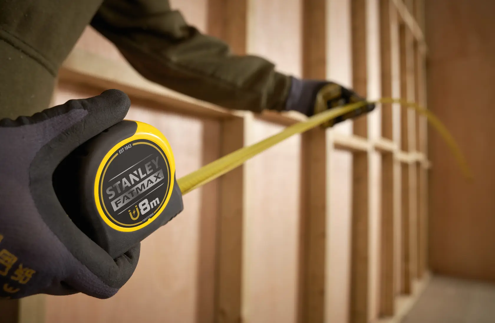 Stanley FMHT0-33868 mètre à ruban avec lame jaune déployée dans un environnement de construction.