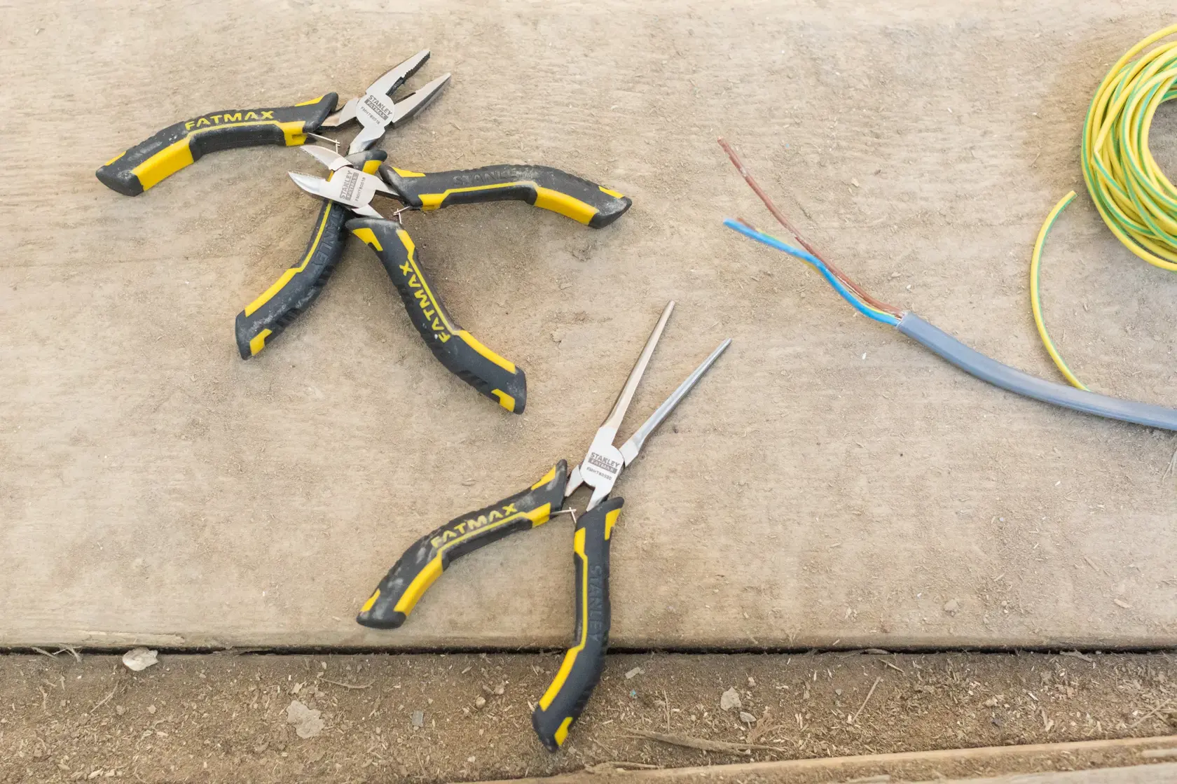 STANLEY FMHT0-80524 pliers set with yellow and black handles on a work surface with electrical wires.