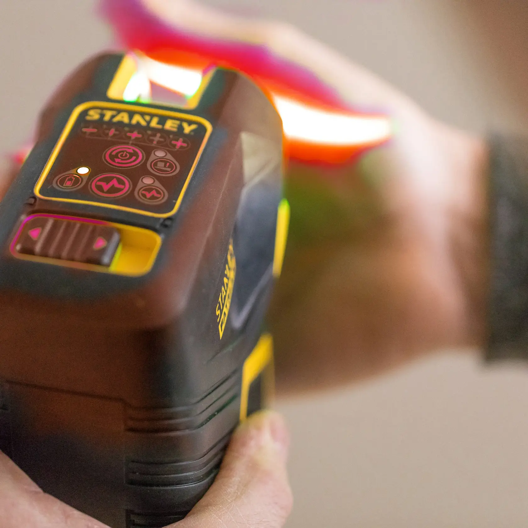STANLEY FMHT1-77414 handheld wall scanner with control panel, shown in use, close-up photography.