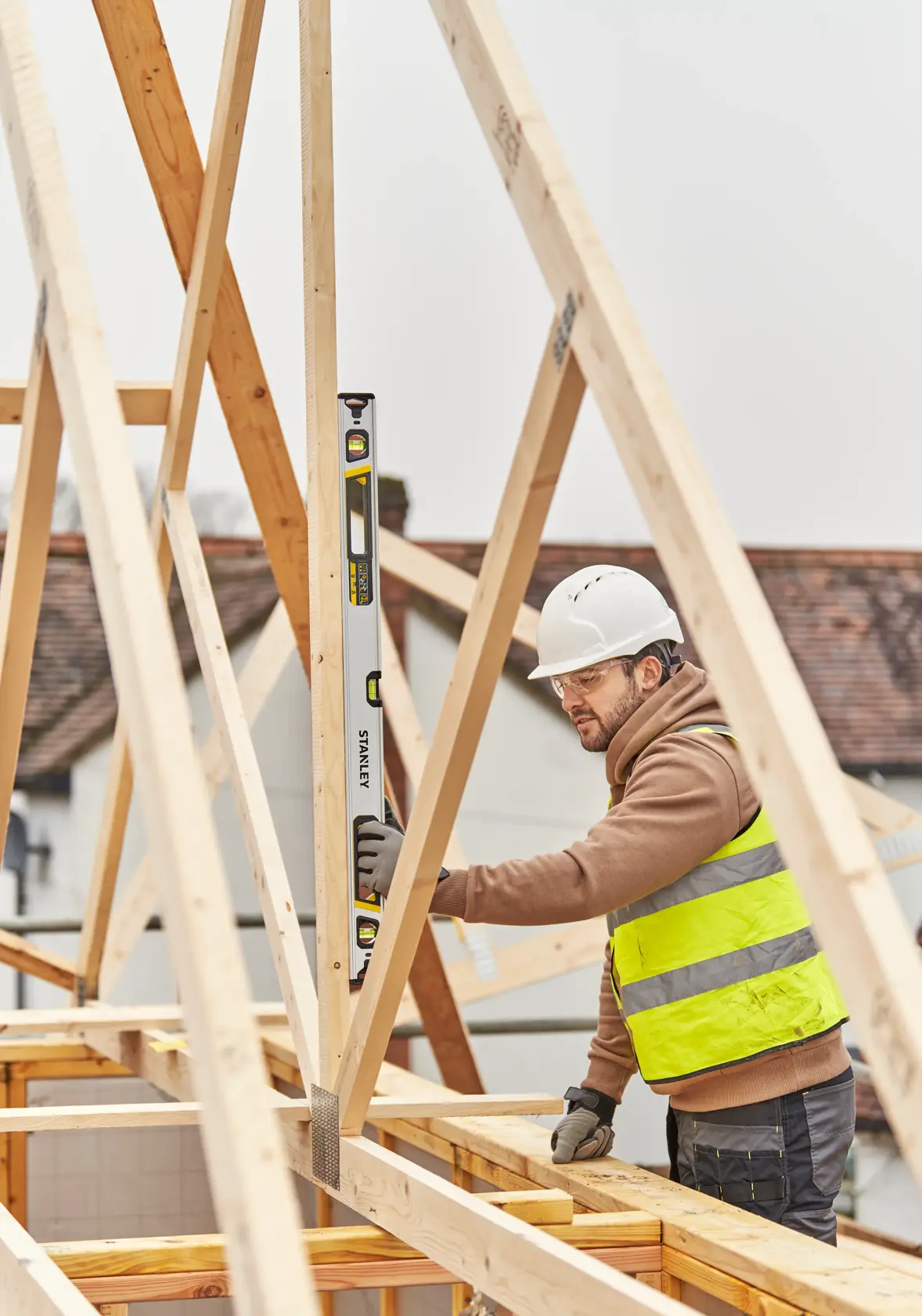 STANLEY FMHT43675-1 spirit level held vertically by construction worker checking wooden frame.