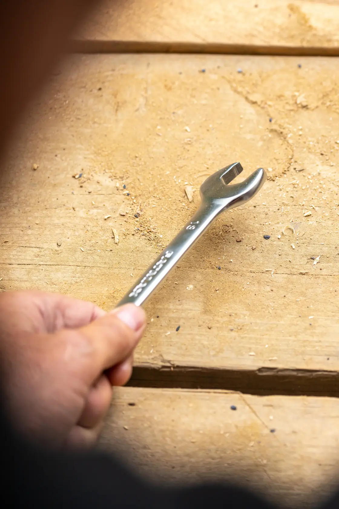 Photo of STANLEY FMMT13029-0 open-ended wrench held over a wooden surface.
