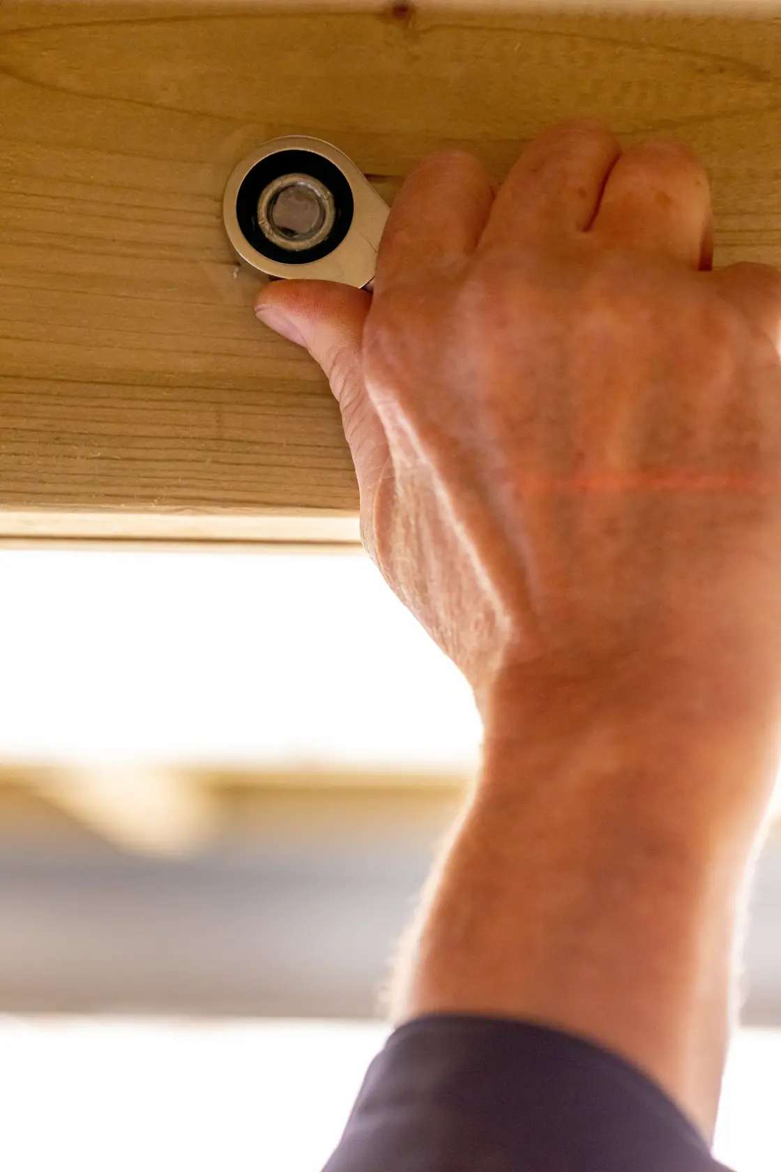 STANLEY FMMT13109-0 ratcheting wrench tightening bolt on wood beam, close-up, product in use.