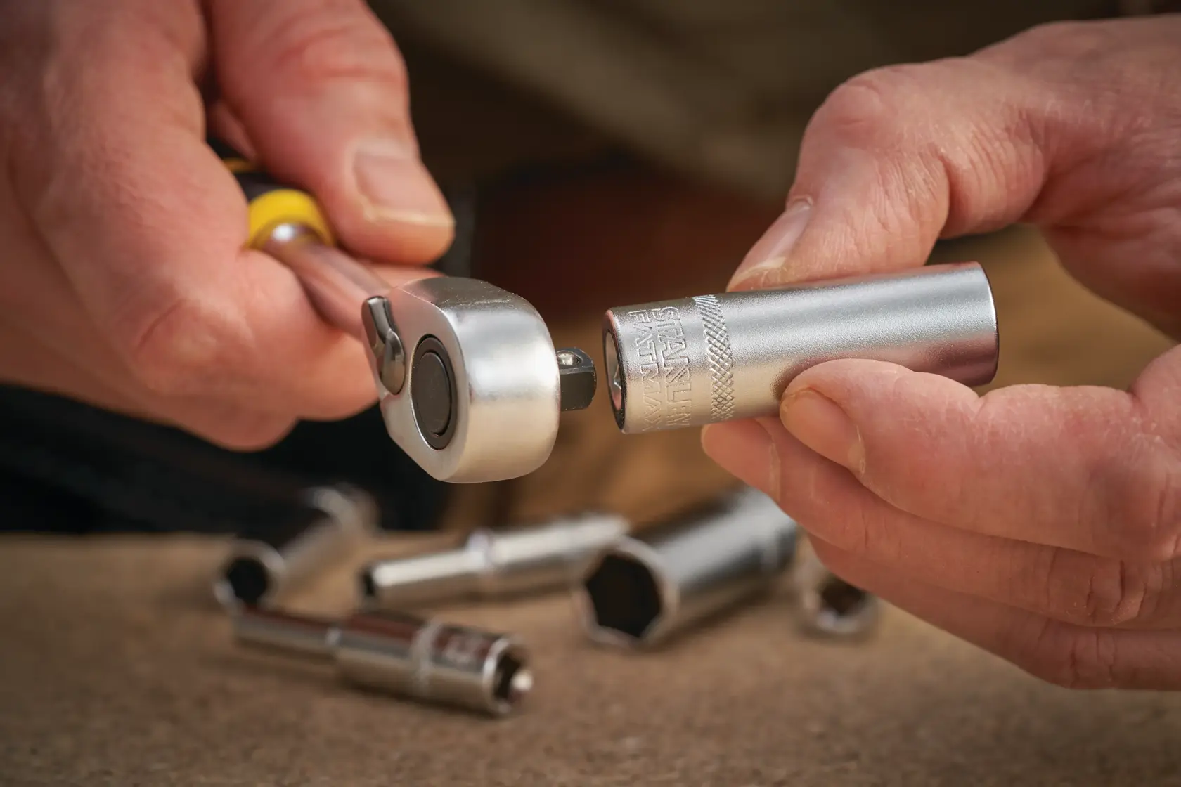 STANLEY FMMT17338-0 ratchet handle with socket, close-up view, silver tool parts on table.