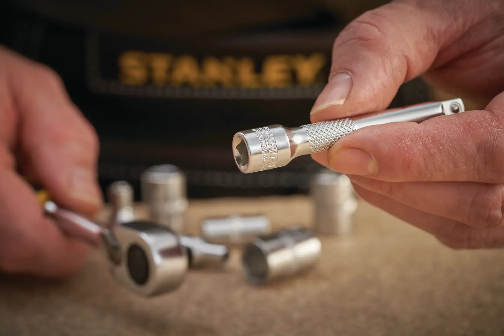 Foto di STANLEY FMMT25125-0 chiave a bussola e accessorio tenuti in mano con altre bussole vicine.