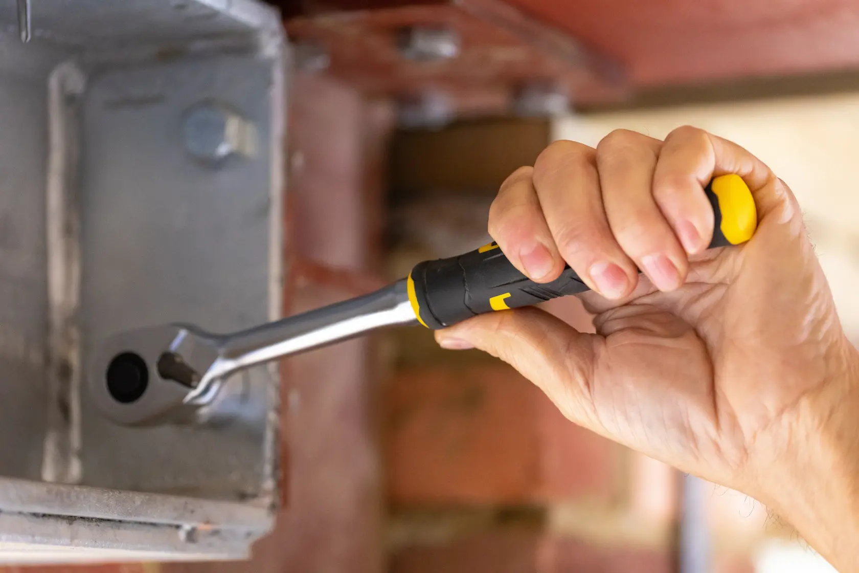 STANLEY FMMT82681-0 ratchet wrench with black and yellow handle in use tightening a bolt.