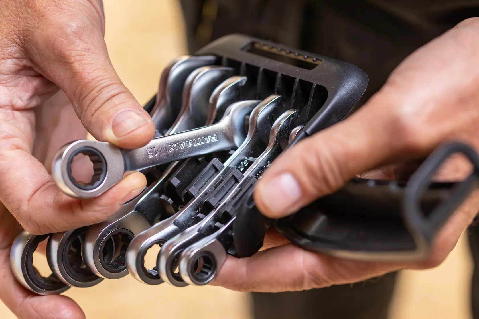 STANLEY FMMT82900-0 ratcheting wrench set in black plastic holder, close-up view, held by hands.