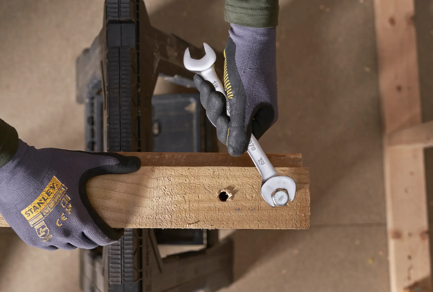 STANLEY FMMT82902-0 wrench in use tightening a bolt on a wooden plank, close-up from above.