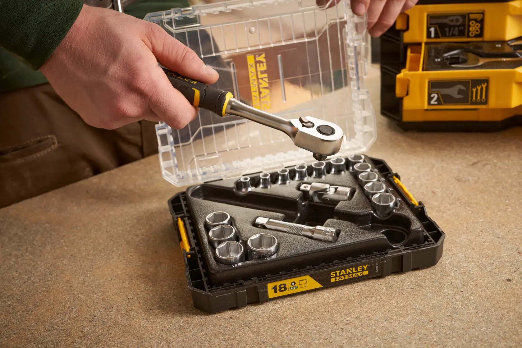 STANLEY FMMT98102-0 socket wrench set open on table, with hand holding ratchet.