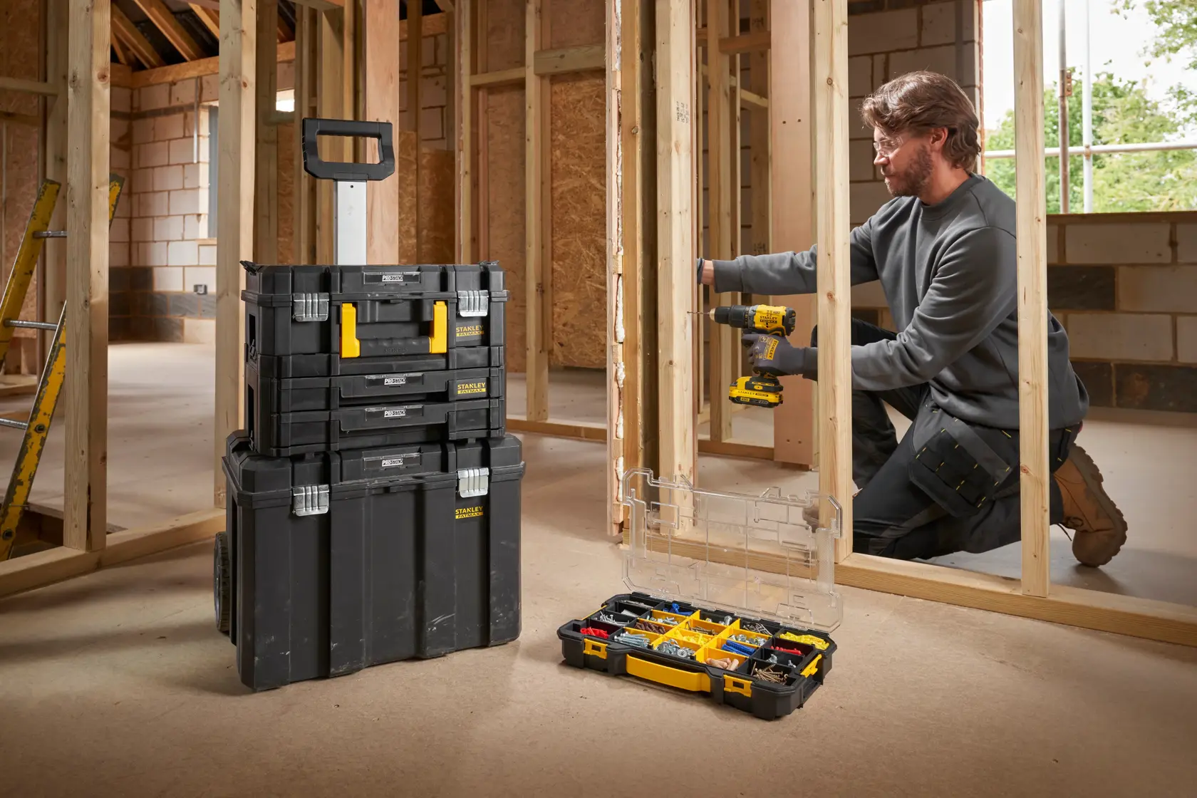 STANLEY FMST17838-1 cassettiera modulare nera e gialla con ruote e organizer aperto in cantiere.