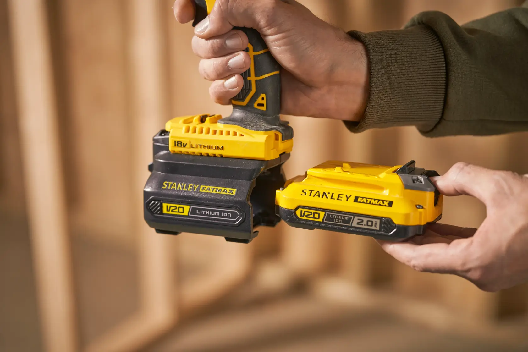 Photo de batteries lithium-ion STANLEY FATMAX V20, SKU SFMCB100, fixées à un outil électrique.