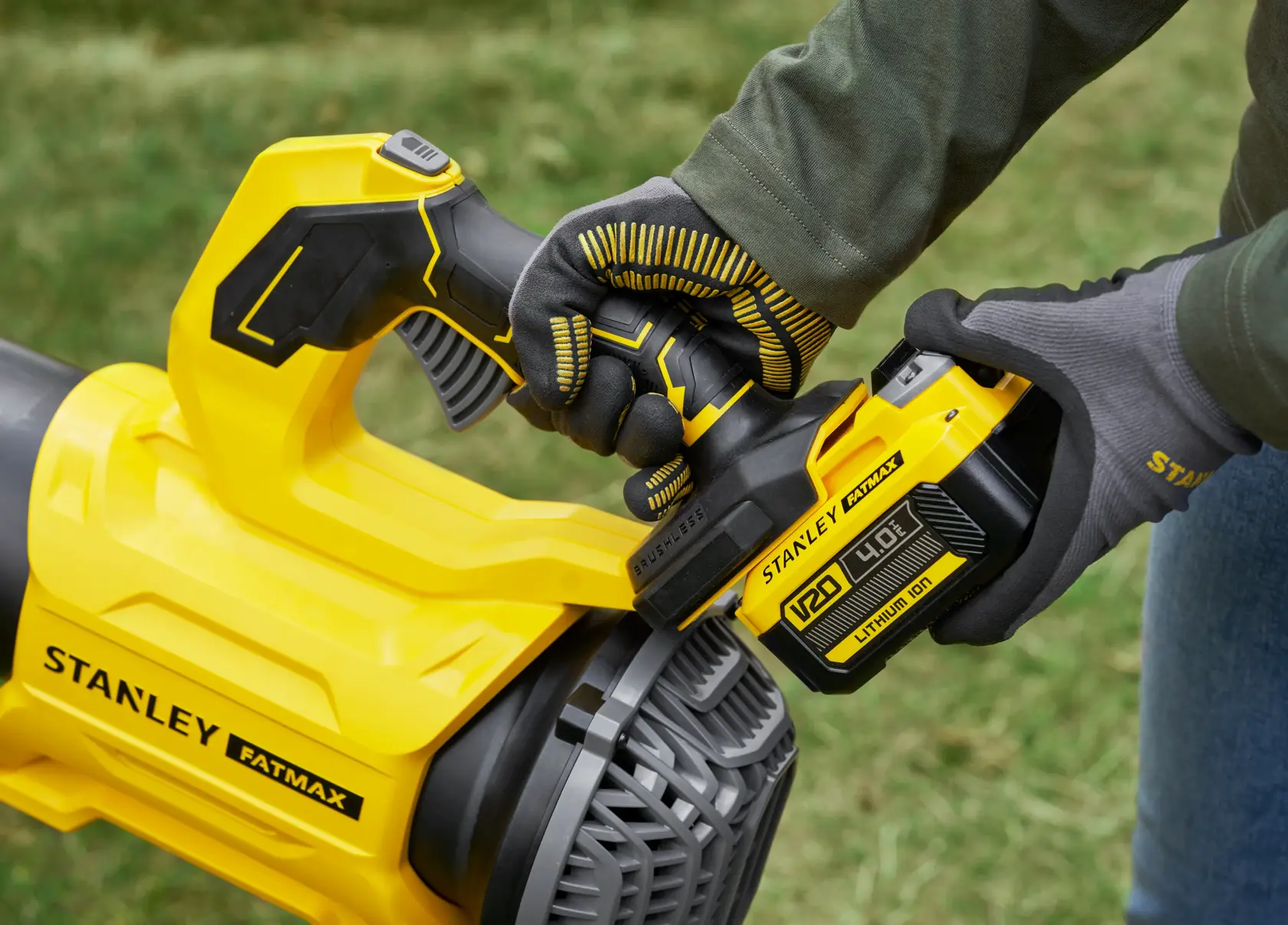 STANLEY SFMCBL730M1 soffiatore senza fili primo piano con mano guantata che installa la batteria, all'aperto.