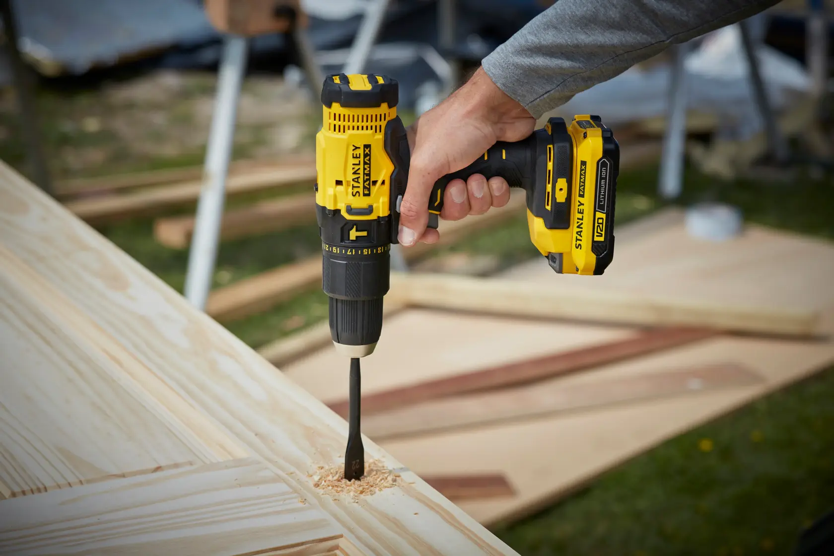 STANLEY SFMCD711B perceuse sans fil utilisée sur du bois, gros plan du outil jaune et noir.