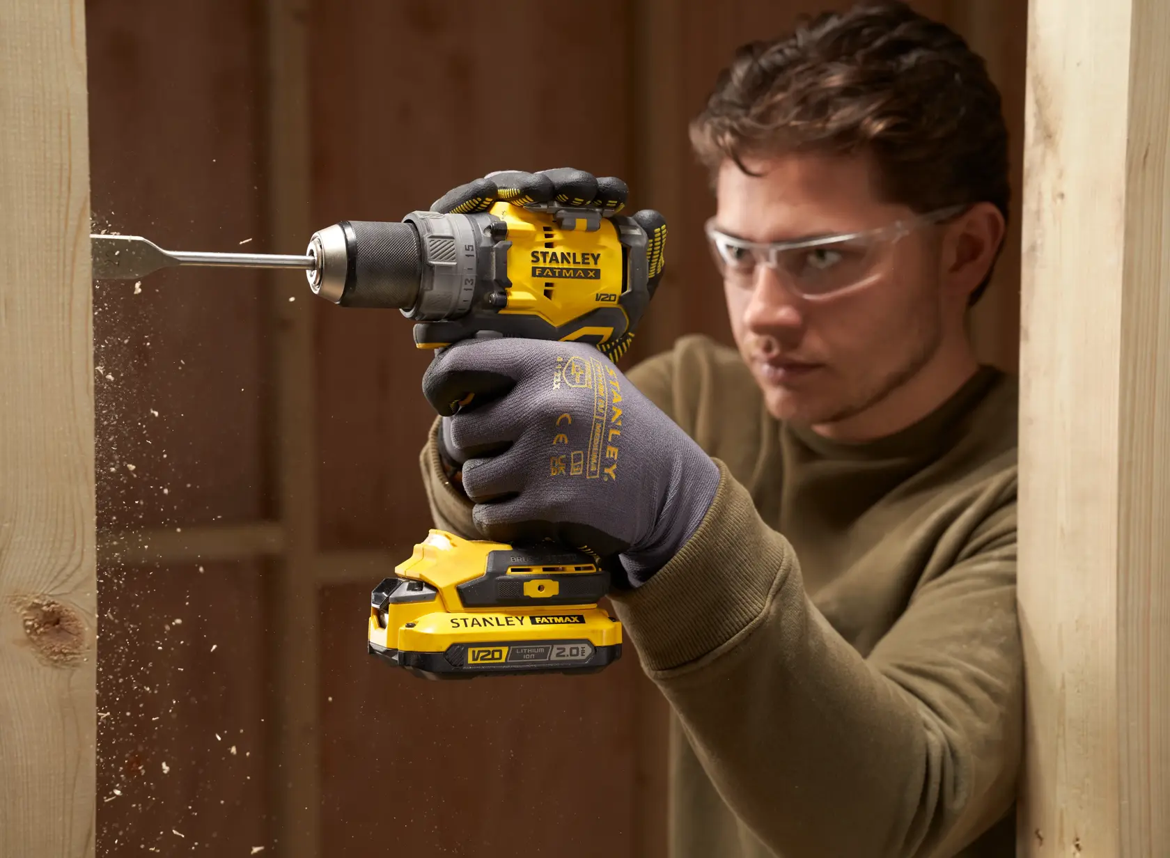 Foto del trapano a batteria STANLEY SFMCD725B in uso, fora legno, design giallo e nero.