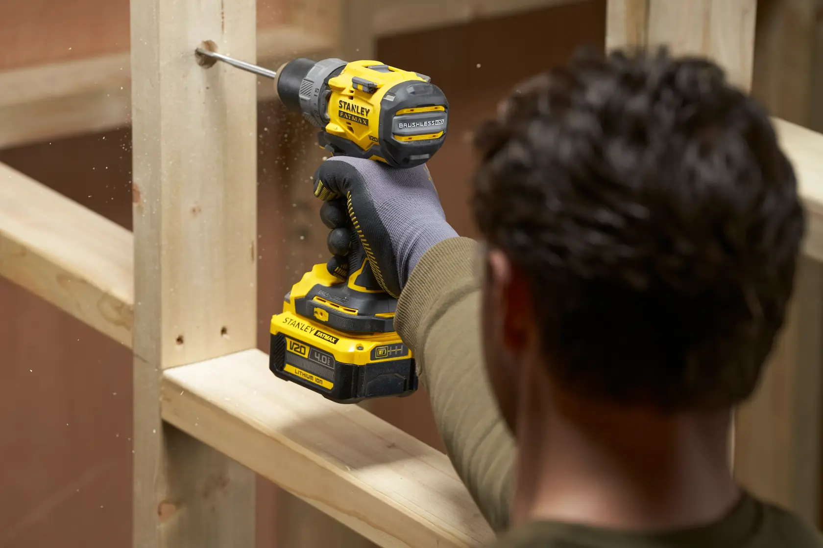 Foto del trapano a batteria STANLEY SFMCD725B in uso su legno, angolo laterale, design nero e giallo.