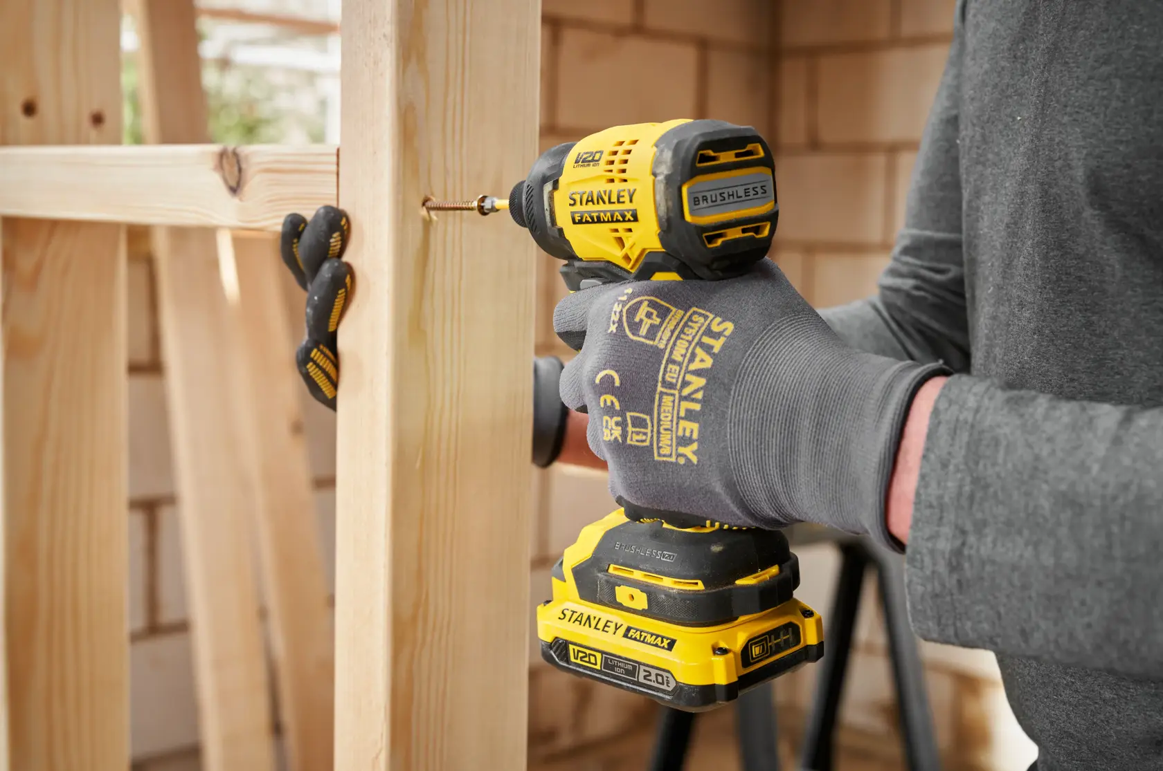 STANLEY SFMCF811D1T visseuse à chocs en usage, vissage dans le bois, vue rapprochée de côté.