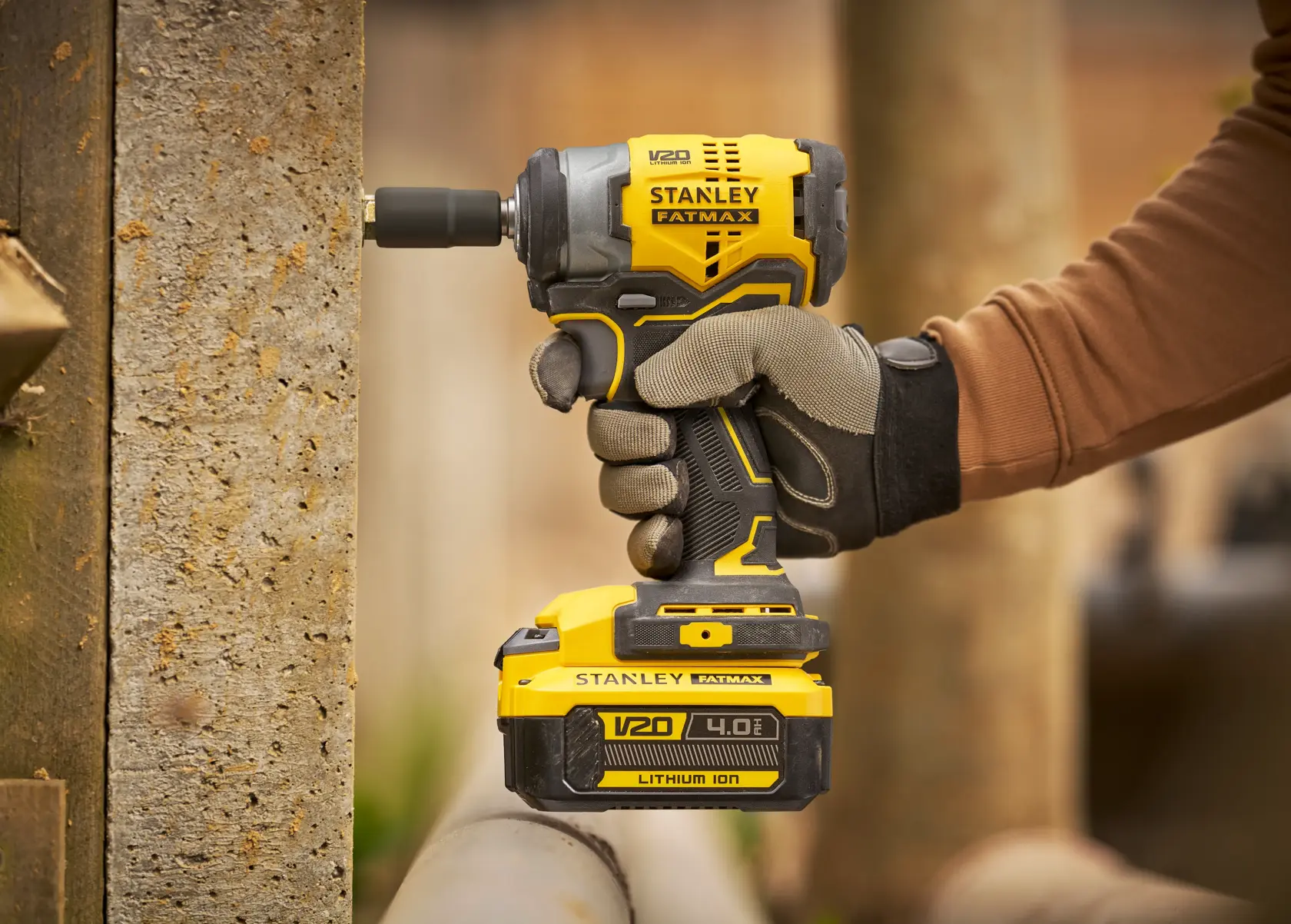 Foto di avvitatore a impulsi STANLEY SFMCF910B in uso, design giallo e nero, batteria al litio V20 4.0Ah.