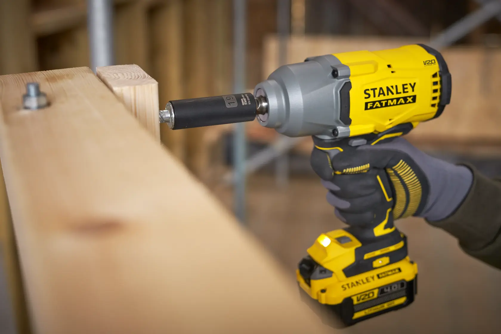 Foto dell’avvitatore a impulsi senza fili STANLEY SFMCF940M1 in uso su una trave di legno, vista ravvicinata.