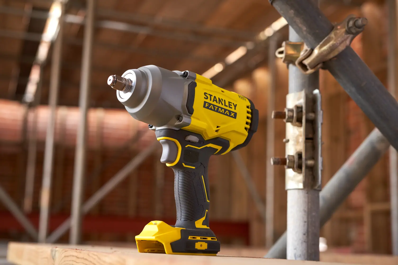 Avvitatore ad impulsi a batteria STANLEY SFMCF940M1 in cantiere, corpo giallo e nero, vista laterale.