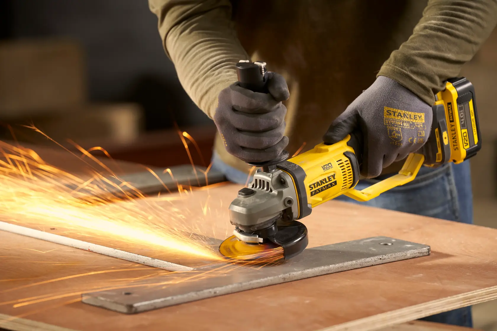 STANLEY SFMCG300B meuleuse d’angle sans fil en utilisation, meulant du métal avec des étincelles, vue rapprochée.