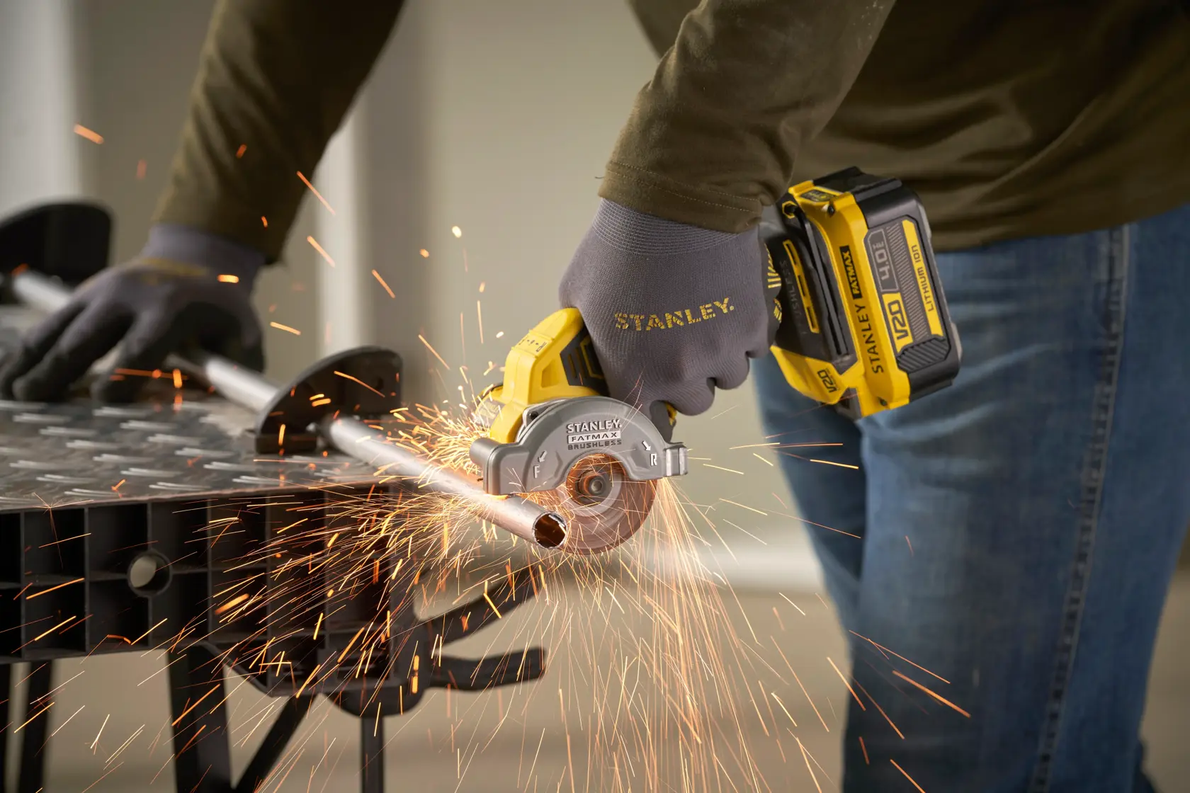 STANLEY SFMCM300B compact cordless circular saw cutting metal pipe with sparks, close-up action.