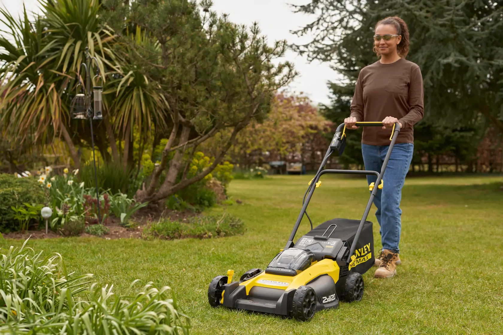 STANLEY FATMAX cordless lawn mower with black and yellow design, grass bag, and push handle.