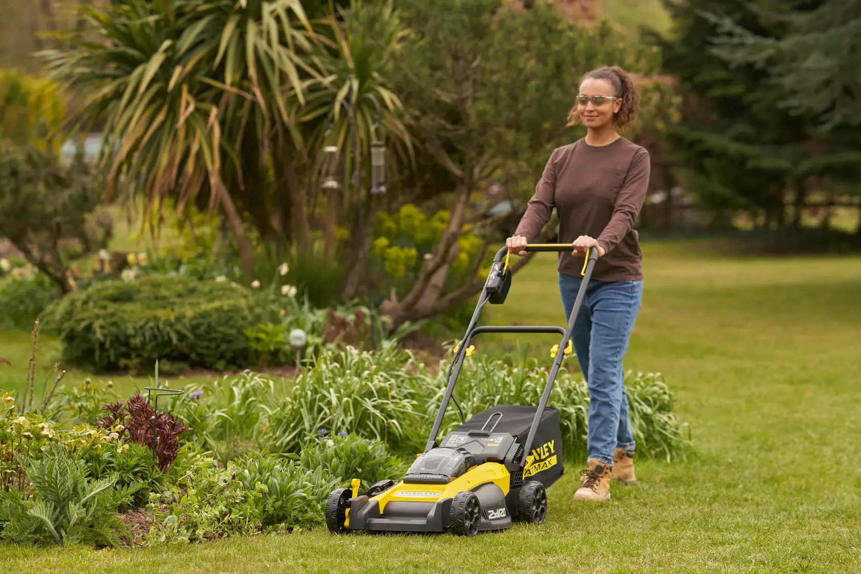 Stanley Fatmax cordless lawn mower with large rear grass bag and ergonomic handle, side view.