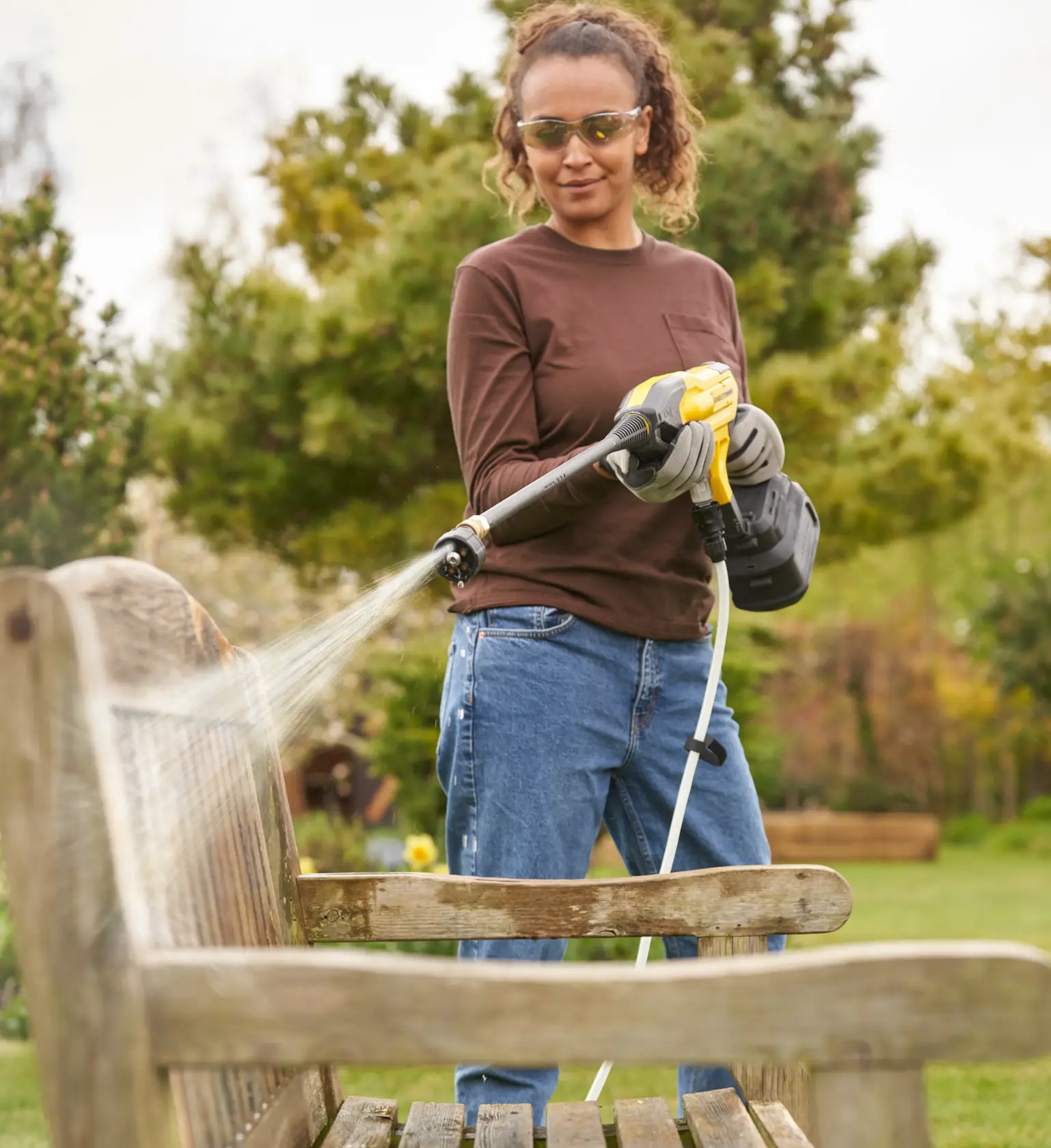 STANLEY cordless pressure washer with yellow and black design, long nozzle and battery pack for portable cleaning.