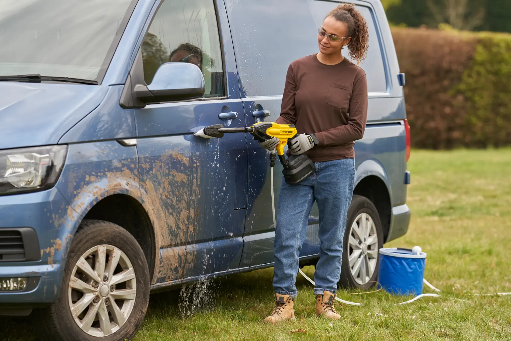 STANLEY SFMCPC93B laveuse portable utilisée pour nettoyer une camionnette bleue boueuse en extérieur.