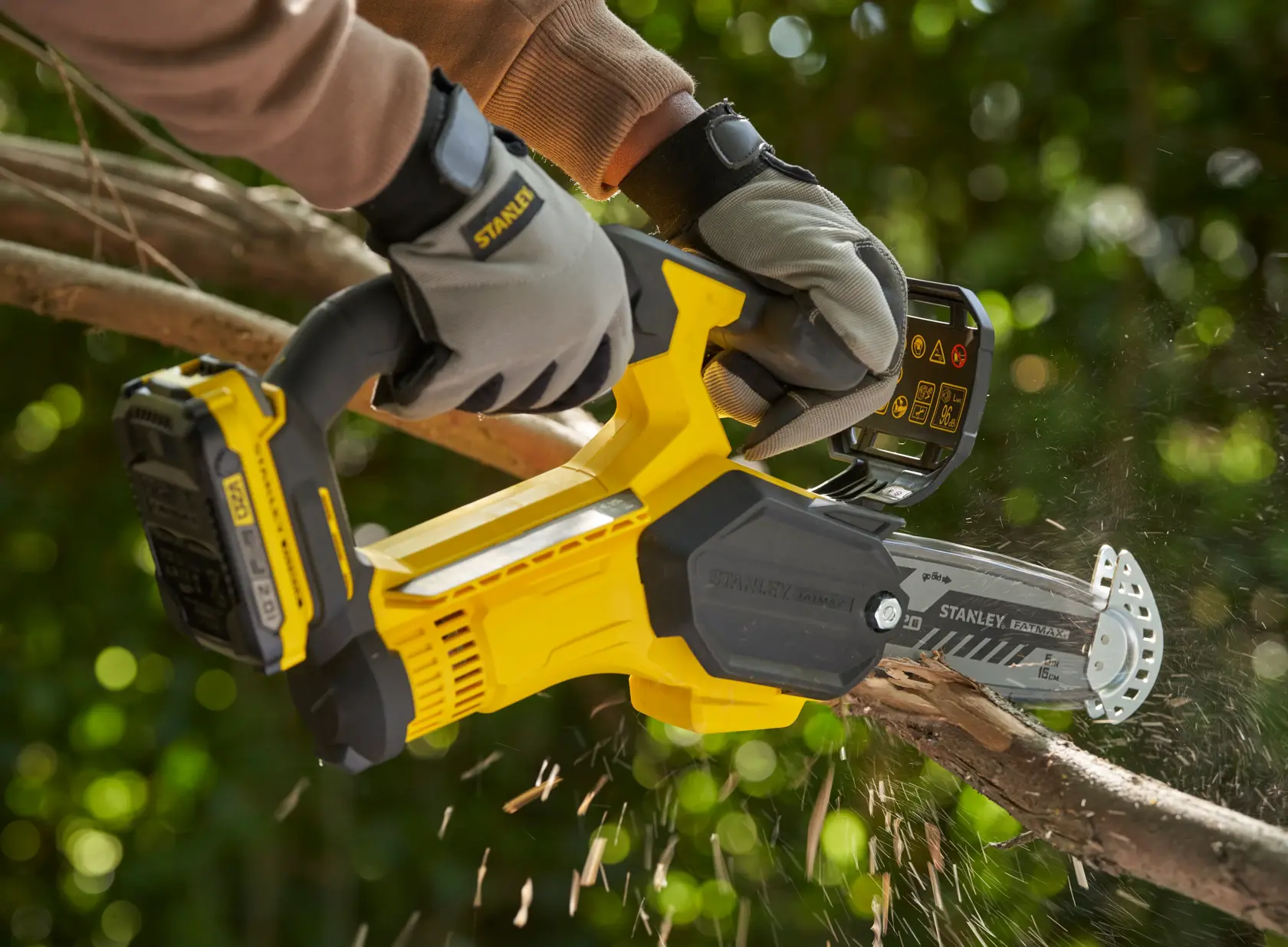 STANLEY SFMCPS415D1 potatrice a batteria che taglia un ramo d’albero all’aperto, vista ravvicinata in azione.