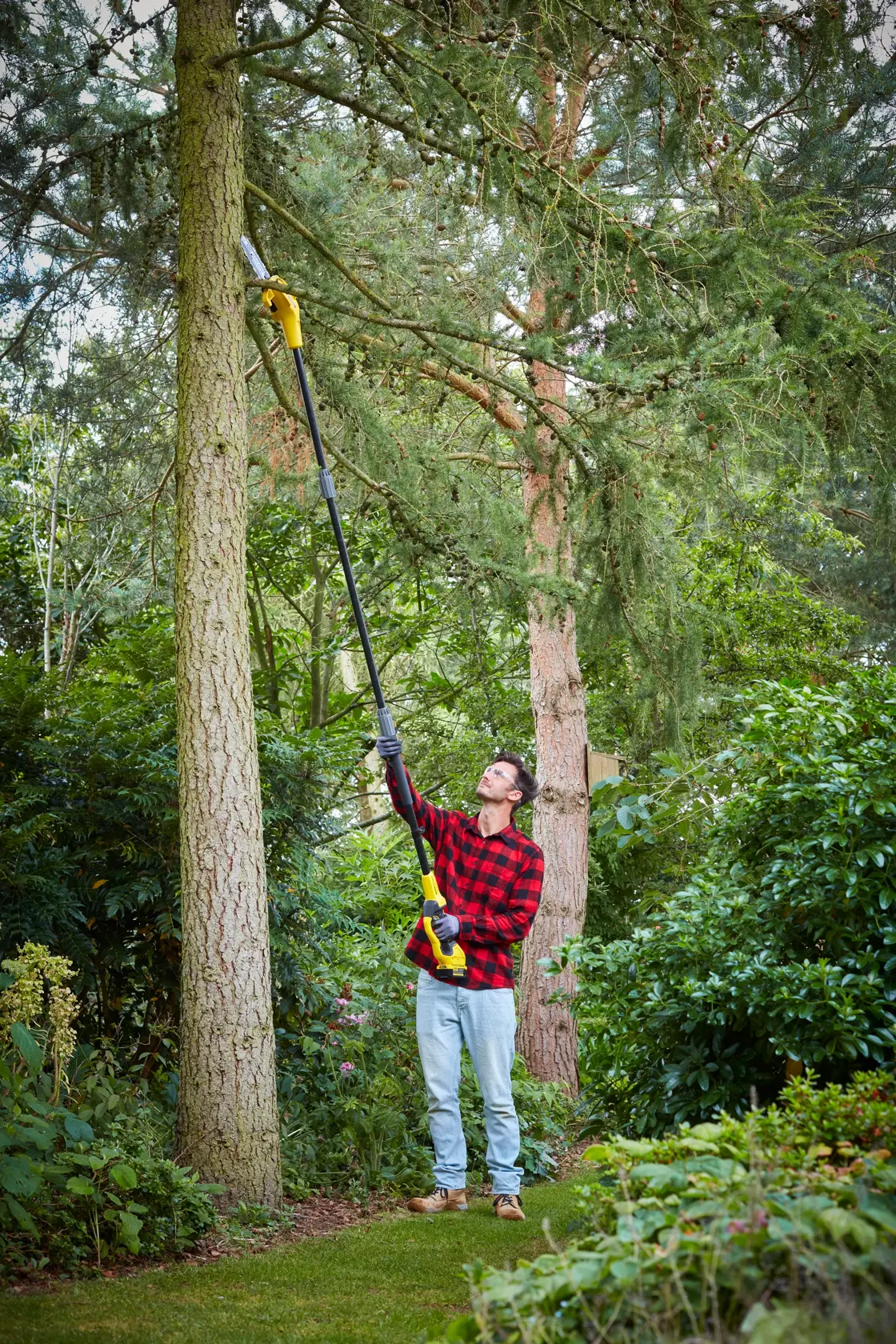 STANLEY SFMCPS620M1 potatore a asta utilizzato all'aperto per potare rami alti in un giardino.