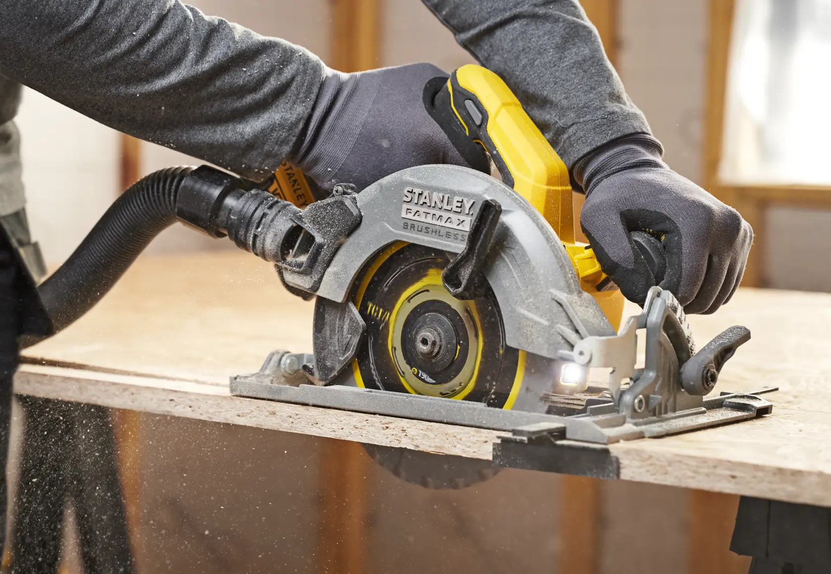 STANLEY SFMCS551B circular saw in use cutting wood, close-up side view showing blade and ergonomic handle.