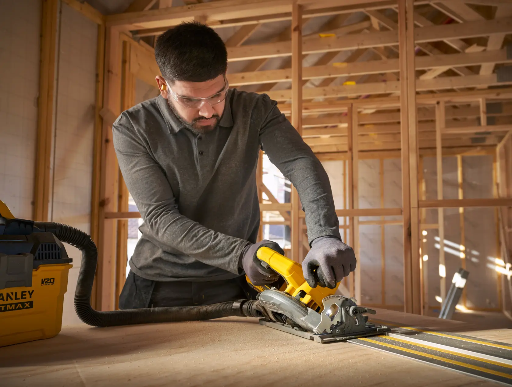 Stanley SFMCS551B circular saw used on wood with guide rail in construction setting.