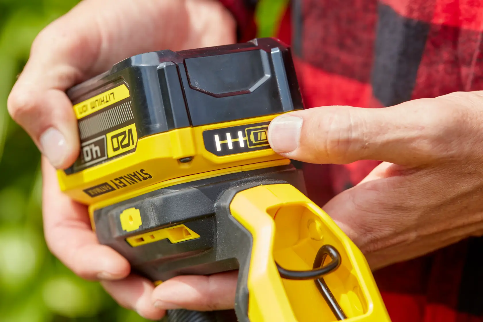 Photo of STANLEY SFMCST933B cordless tool battery in close-up, showing battery level indicator and yellow handle.