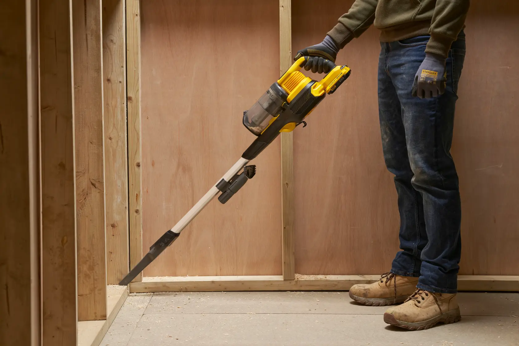 Aspirapolvere portatile STANLEY SFMCVS001D1 giallo e nero in uso, pulizia di un angolo di cantiere.