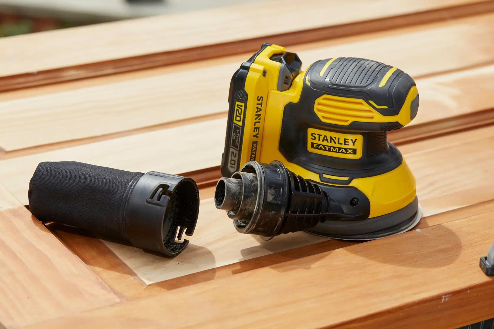 STANLEY SFMCW220D1S levigatrice senza fili su superficie di legno, raccoglitore polvere staccato, vista laterale.