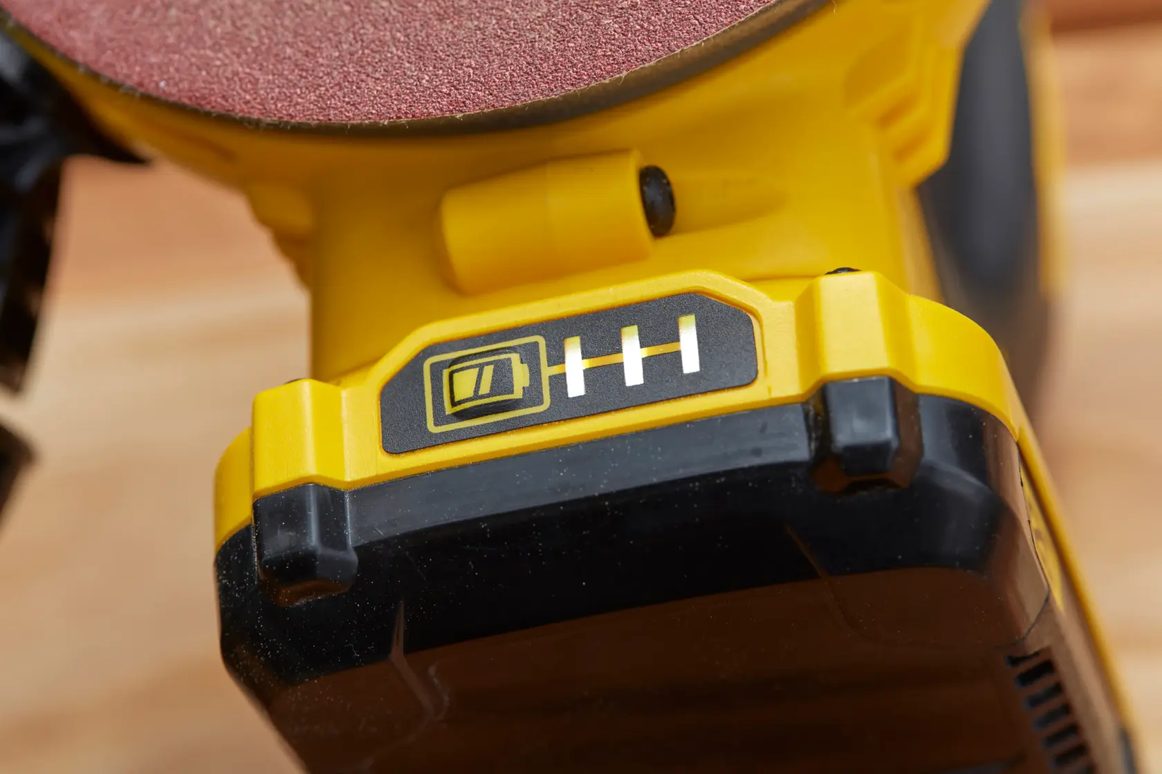 Indicatore batteria in primo piano della levigatrice senza fili STANLEY SFMCW220D1S, corpo giallo e nero, fotografia.