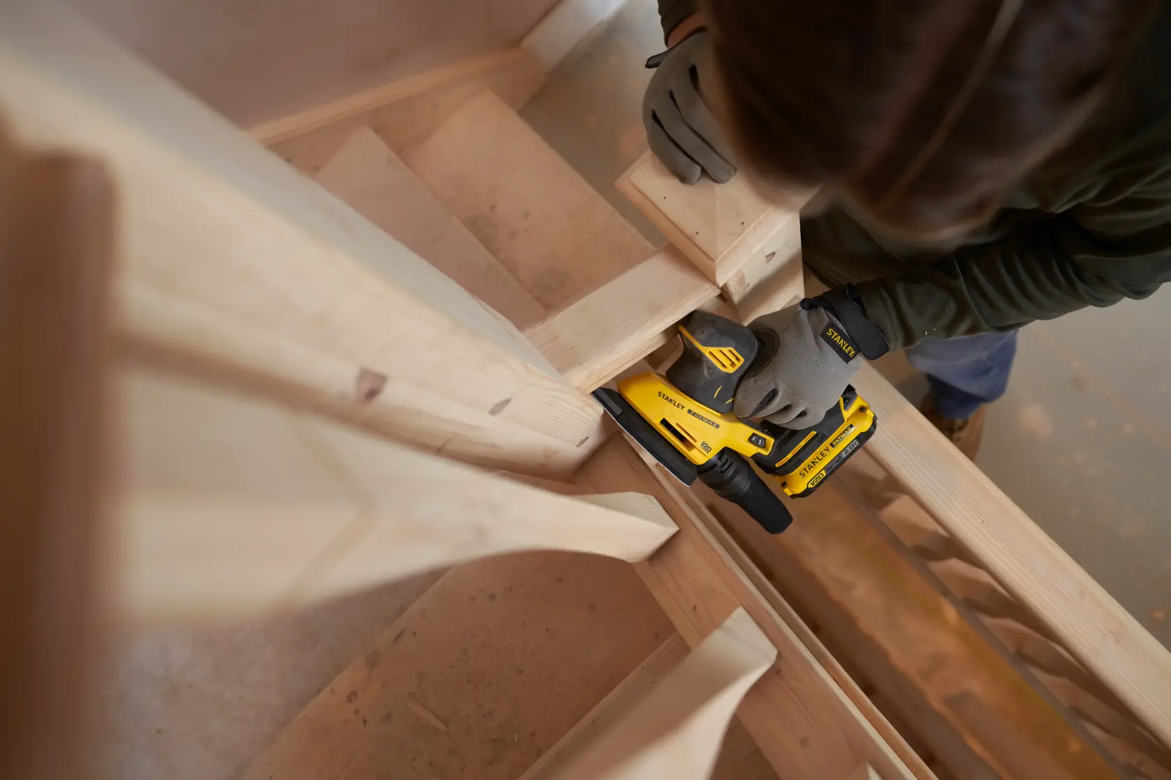 STANLEY SFMCW221D1S cordless sander kit shown with yellow-black bag and charger, front angle.