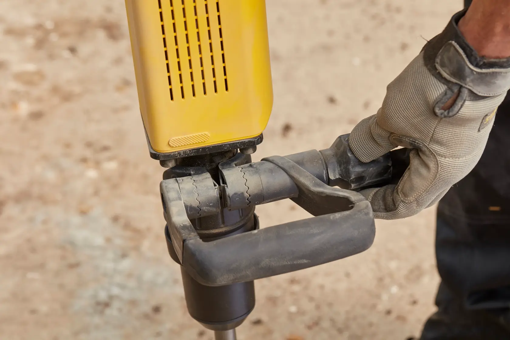 Photo of STANLEY SFMEH230K-QS hammer drill handle held by gloved hand, outdoor close-up.