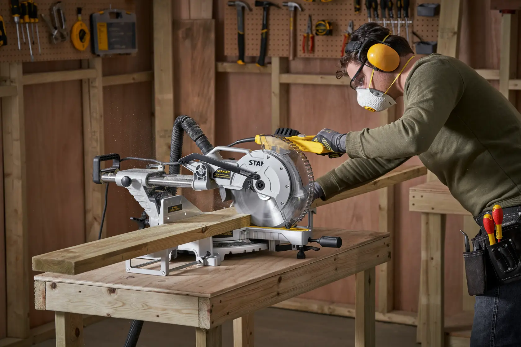 Troncatrice scorrevole STANLEY SM1800 su banco da lavoro, utilizzata per tagliare legno in officina.